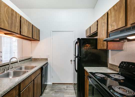 an empty kitchen with a sink and a refrigerator