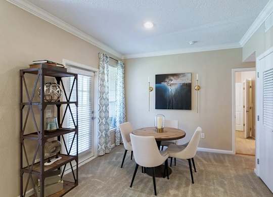 A dining room with a table set for four.