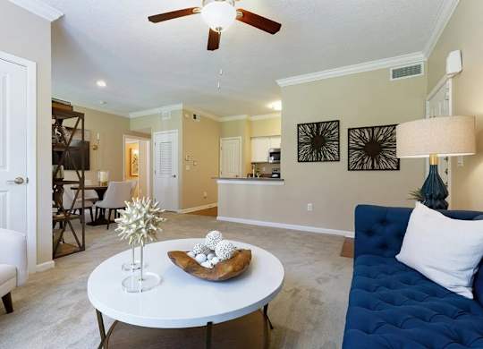 A living room with a white ceiling fan and a white coffee table with a star decoration and a plate of cookies.