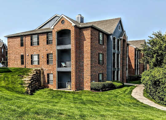 A red brick building with a green lawn in front.