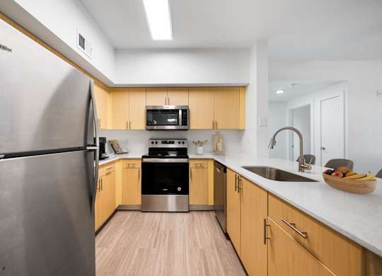 A modern kitchen with wooden cabinets and stainless steel appliances.