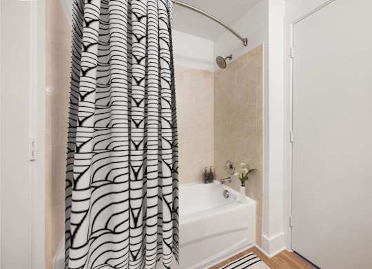 A bathroom with a shower curtain and a white bathtub.