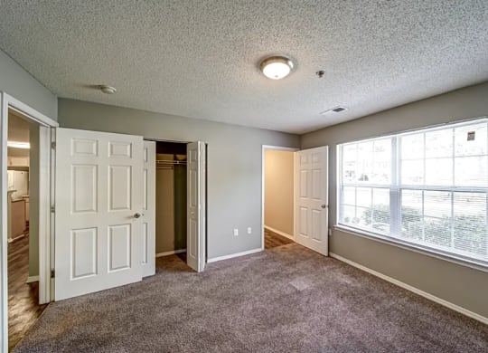 a living room with a large window and a door to a closet