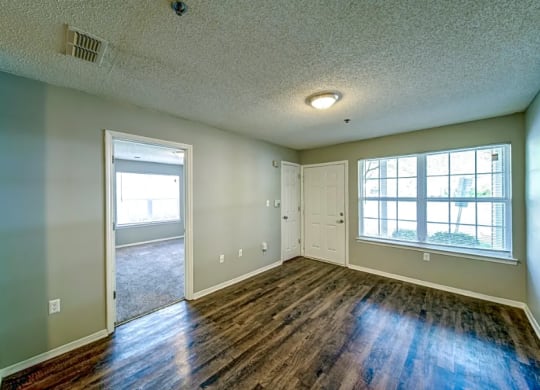 the living room and dining room of an empty house with wood floors