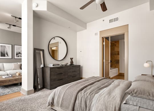 A bedroom with a large bed, a dresser, and a mirror.