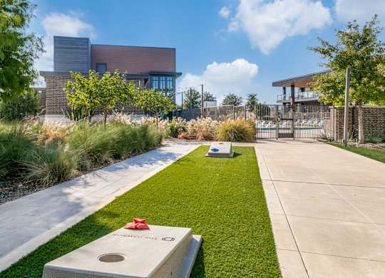 A modern building with a red roof and a green lawn in front.