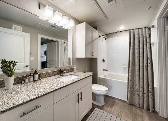 A bathroom with a white toilet, sink, and bathtub.