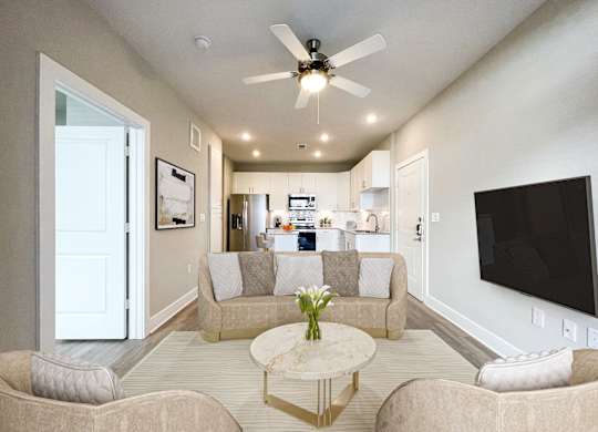 A living room with a beige couch, a coffee table, and a ceiling fan.