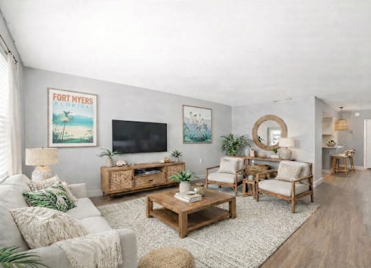 A living room with a flat screen TV, a white sofa, and a wooden coffee table.