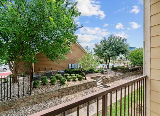 A house with a brown fence and a green tree.