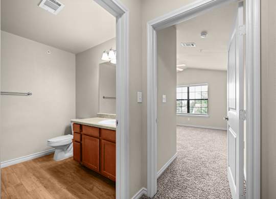 A bathroom with a toilet, sink, and mirror.