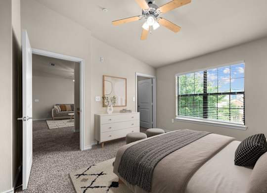 A bedroom with a large bed and a ceiling fan.
