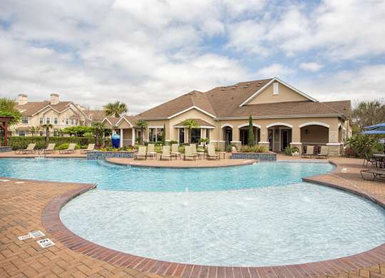 A large swimming pool in front of a house.