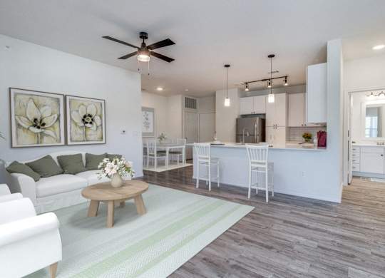 an open living room and kitchen with a ceiling fan