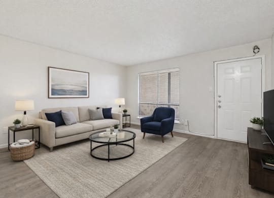 A living room with a couch, chair, and television.