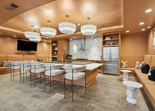 A modern kitchen with a bar area and a refrigerator.