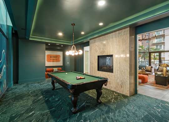 A pool table in a room with a green carpet.