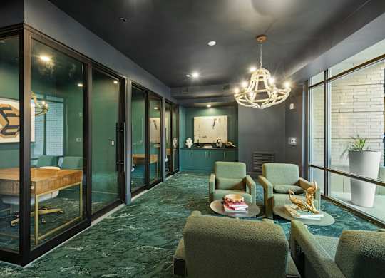 A room with a green carpet and a chandelier hanging from the ceiling.