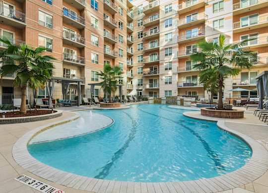A large outdoor swimming pool surrounded by apartment buildings.