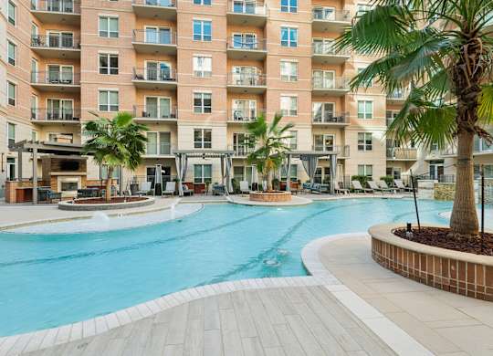 A large swimming pool in front of apartment buildings.