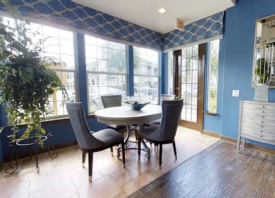 A dining room with a table and chairs.
