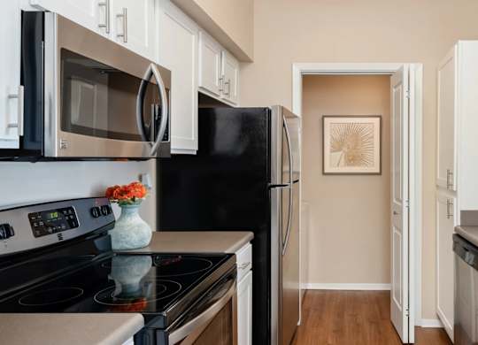 A kitchen with black appliances and white cabinets.