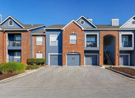 A row of red brick houses with blue garage doors.