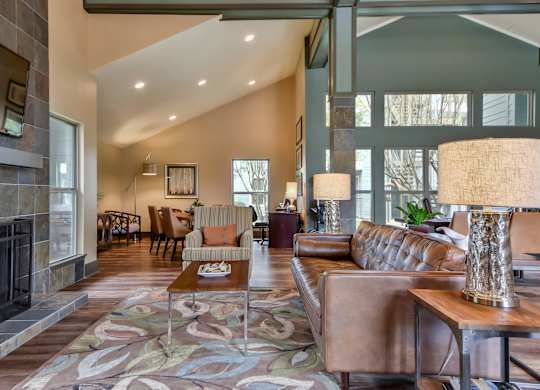 A living room with a brown leather couch and a patterned rug.