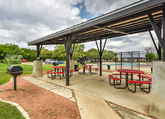 A picnic area with tables and benches under a shelter.