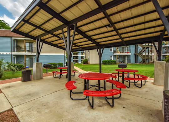 Picnic tables and chairs are set up under a canopy.