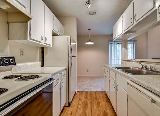 A kitchen with white cabinets and a stove top oven.