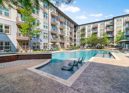 A large swimming pool in front of apartment buildings.