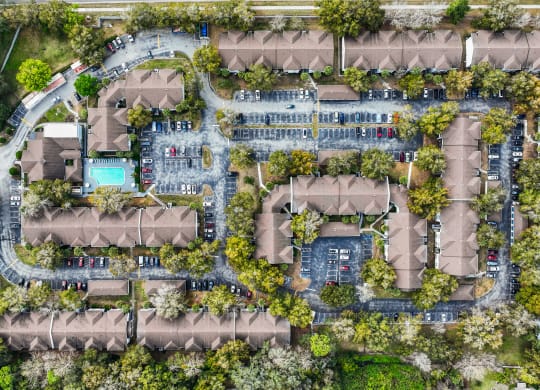 a birds eye view of a residential neighbourhood with trees and a pool