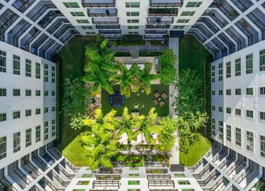 an aerial view of a courtyard in a building with trees and plants