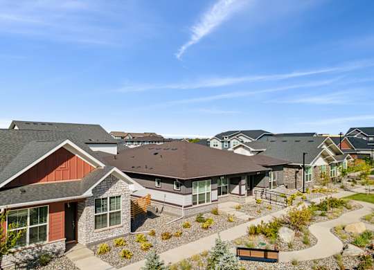 A sunny day at a residential complex with houses and a clear blue sky.