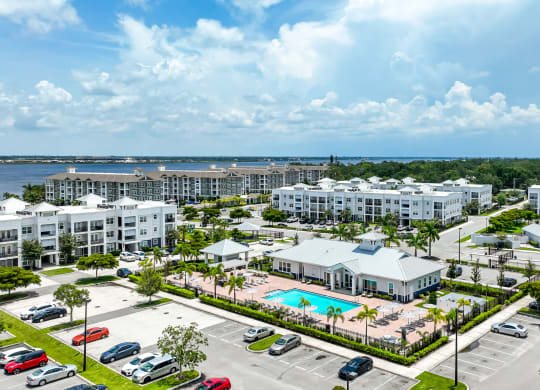 an aerial view of the resort with a pool and parking lot