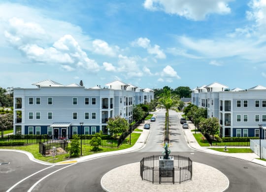a street with houses on both sides and a fountain in the middle of the road