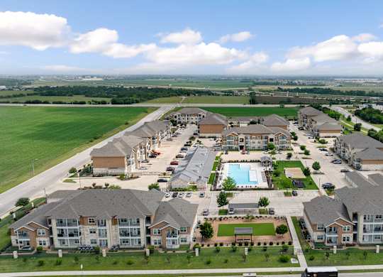 A large apartment complex with a swimming pool in the middle.