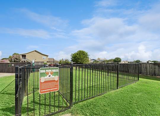 A sign in a fenced area reads