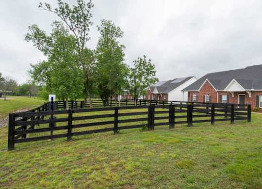 A black fence in front of a red brick house.