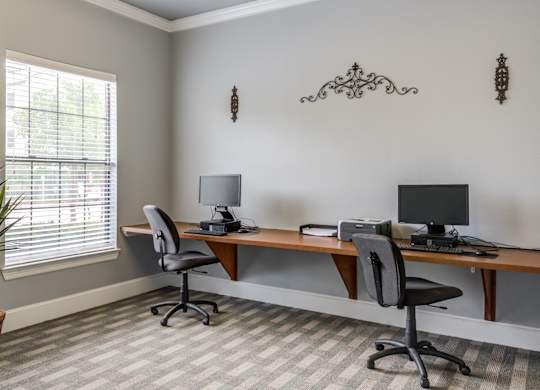 A room with a desk and two chairs.