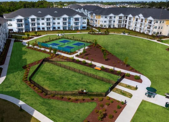 an aerial view of a park with apartments in the background