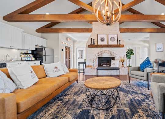 A living room with a fireplace and a large rug.