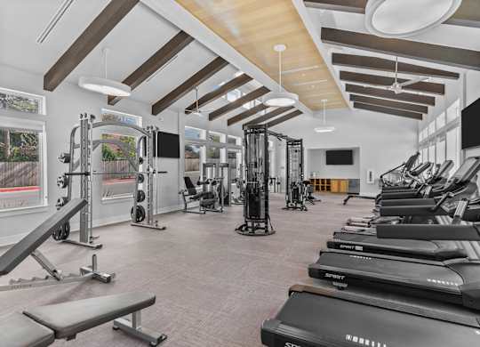 A gym with treadmills, weights, and exercise equipment.