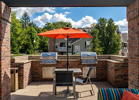 A patio with a table, chairs and an umbrella.