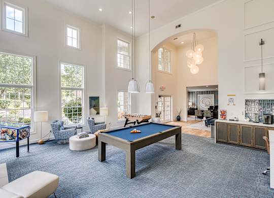 A billiard table is in the middle of a room with a pool table and a couch.