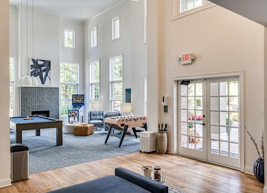 A living room with a pool table and a foosball table.