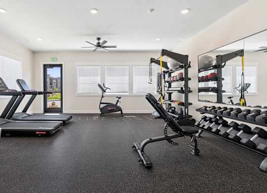 A spacious gym with treadmills, elliptical machines, and weightlifting equipment.