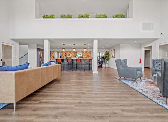 a view of the clubhouse with couches chairs and a bar in the background