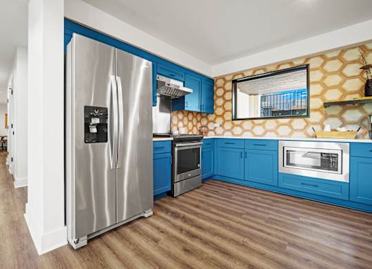 a kitchen with blue cabinets and stainless steel appliances